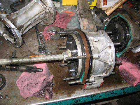 1995 Ford C-350 (Centurion Conversions) - A close-up view of a disassembled transmission part, showing gears and seals on a cluttered workbench.