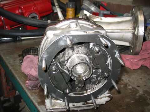 1995 Ford C-350 (Centurion Conversions) - Close-up of a disassembled mechanical part, likely from a vehicle's drivetrain, on a cluttered workbench.