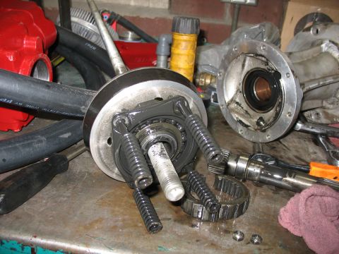1995 Ford C-350 (Centurion Conversions) - A disassembled transmission part, springs and gears, is laid out on a workbench for repair or inspection.