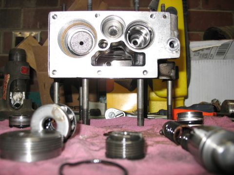 1995 Ford C-350 (Centurion Conversions) - A disassembled metal component, likely from a vehicle's transmission or engine, is laid out on a pink cloth with tools in the background.