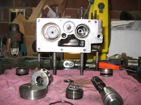 1995 Ford C-350 (Centurion Conversions) - Disassembled hydraulic pump components are spread out on a workbench, ready for repair or inspection.