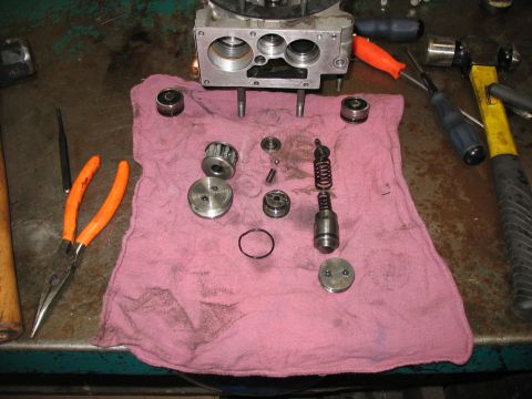 1995 Ford C-350 (Centurion Conversions) - Various components of a hydraulic pump are spread out on a cloth, ready for reassembly or inspection.