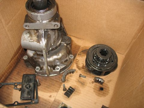 1995 Ford C-350 (Centurion Conversions) - Disassembled transmission components are laid out in a cardboard box, showing various gears and a transfer case.