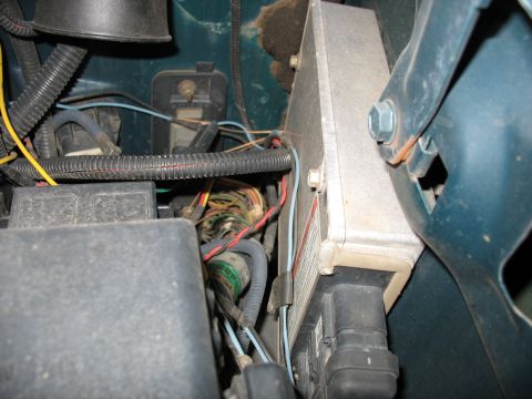 1995 Ford C-350 (Centurion Conversions) - Close-up view of the engine control module and associated wiring harness in a vehicle's engine bay.