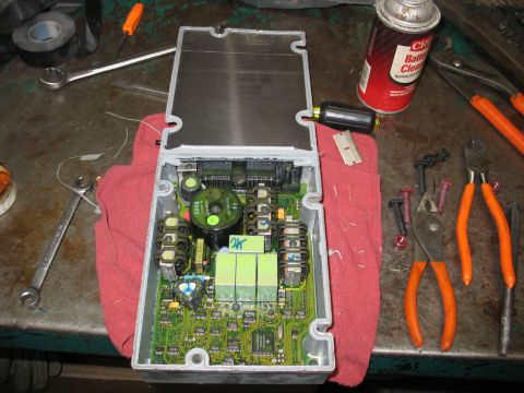 1995 Ford C-350 (Centurion Conversions) - An open electronic control unit is shown on a workbench with various tools scattered around it.