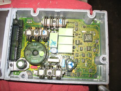 1995 Ford C-350 (Centurion Conversions) - The internal components of an engine control module are exposed, showing a complex circuit board with various electronic parts.