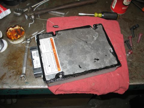1995 Ford C-350 (Centurion Conversions) - Automotive electronic control unit with warning labels and tools on a workbench.