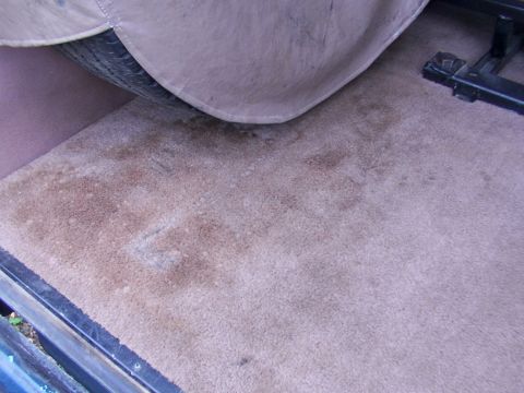 1995 Ford C-350 (Centurion Conversions) - The interior carpet shows stains and is partially covered by a spare tire cover.
