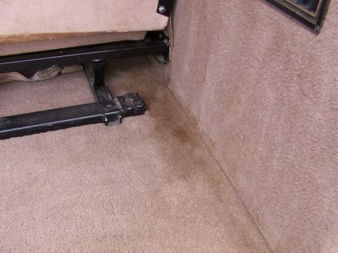 1995 Ford C-350 (Centurion Conversions) - Stain on the carpet of a vehicle's interior, near the seat base.