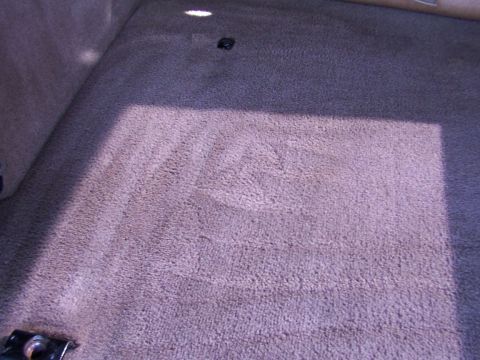 1995 Ford C-350 (Centurion Conversions) - The interior carpet of a vehicle is visible, with a shadow falling across it.