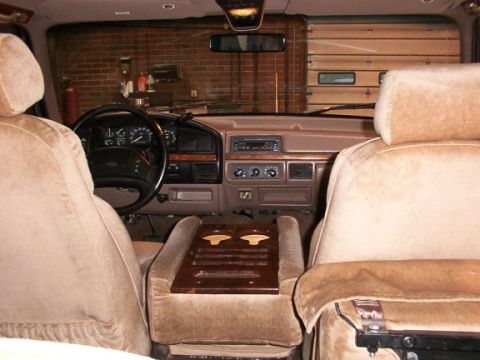 1995 Ford C-350 (Centurion Conversions) - Interior of a 1995 Ford C-350 (Centurion Conversions) van, plush seating and a wooden center console.