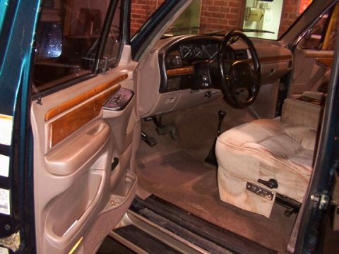 1995 Ford C-350 (Centurion Conversions) - The interior of a Ford truck, tan upholstery and wood grain accents on the door panel.