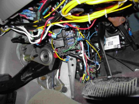 1995 Ford C-350 (Centurion Conversions) - Close-up of a vehicle's interior wiring and pedals, with a control module visible.