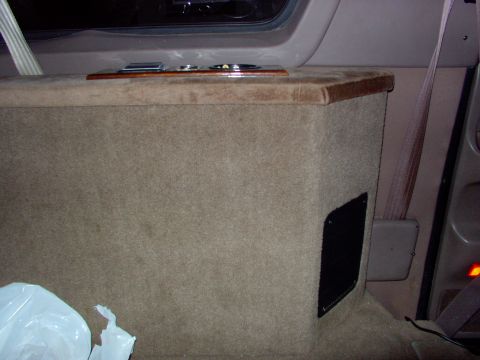 1995 Ford C-350 (Centurion Conversions) - Custom interior console with cup holders and wood trim, covered in tan carpet.