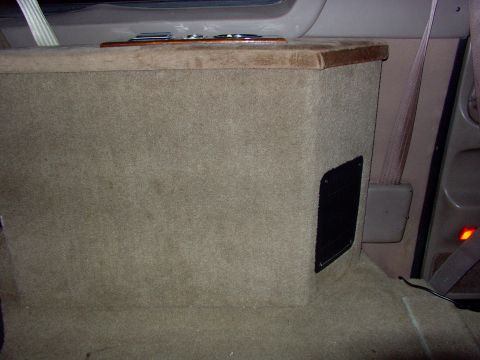 1995 Ford C-350 (Centurion Conversions) - Interior view of a vehicle's console and seatbelt, with tan carpeting and wood accents.