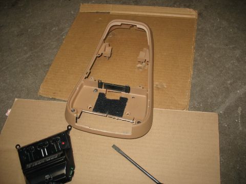 1995 Ford C-350 (Centurion Conversions) - Disassembled overhead console housing and climate control module on cardboard.