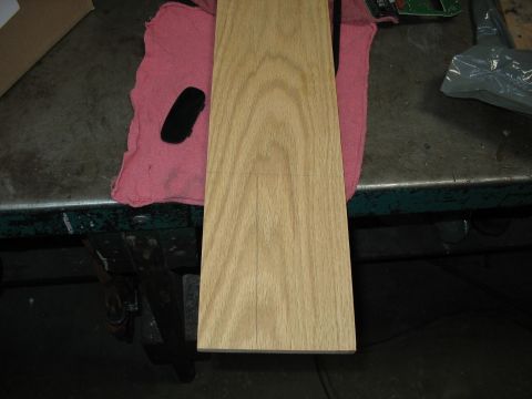 1995 Ford C-350 (Centurion Conversions) - A wooden part, possibly for an overhead console, rests on a pink cloth on a workbench.