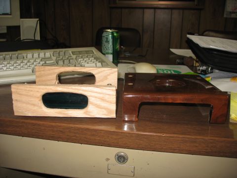 1995 Ford C-350 (Centurion Conversions) - Two wooden overhead console parts with dark inserts sit next to a dark brown plastic console part on a desk.
