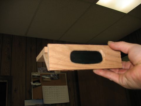 1995 Ford C-350 (Centurion Conversions) - A wooden part, possibly for an overhead console, is held up for inspection.