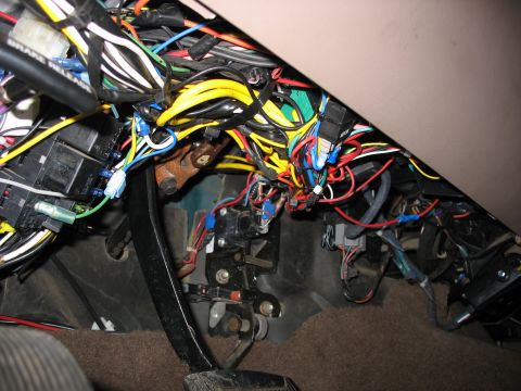 1995 Ford C-350 (Centurion Conversions) - A complex network of wires and electrical components is visible under the dashboard of a vehicle.