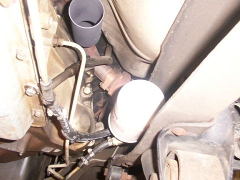 1995 Ford C-350 (Centurion Conversions) - Underside view of a transmission filter and exhaust pipe, likely from a truck or van.