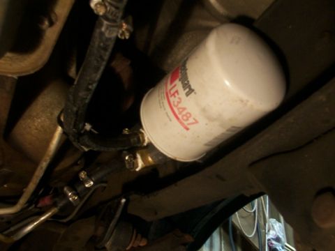 1995 Ford C-350 (Centurion Conversions) - Close-up of an oil filter and hoses, indicating a vehicle maintenance part.