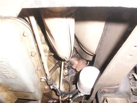 1995 Ford C-350 (Centurion Conversions) - Close-up view of a remote transmission filter and exhaust components, likely from the underside of a vehicle.