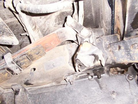 1995 Ford C-350 (Centurion Conversions) - Underside view of a vehicle's suspension system, focusing on the leaf spring shackle and related hardware.