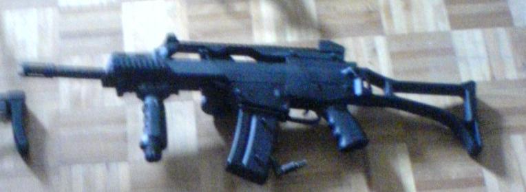Assault rifle with folding stock on a wood-grain surface