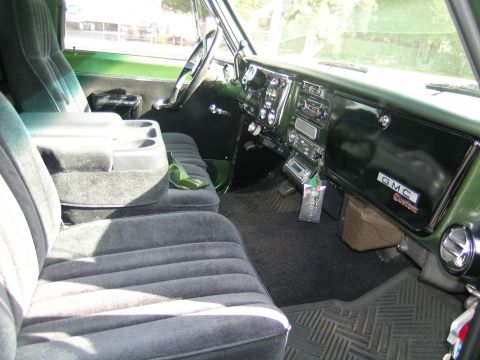 1996 Ford Bronco - The interior of a GMC Custom truck features plush bench seating and a classic dashboard layout.