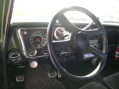 1996 Ford Bronco - The interior of a GMC truck showcases its dashboard with prominent gauges and a classic steering wheel.
