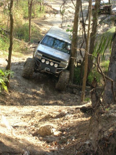 1989 Ford Bronco - This 1989 Ford Bronco is tackling a challenging muddy incline on an off-road trail.
