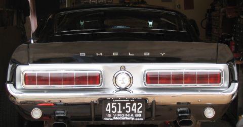 1968 Shelby GT500 - Rear view of a black 1968 Shelby GT500, its distinctive sequential taillights and prominent 'SHELBY' badging.