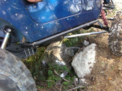 1989 Ford Bronco - This modified Jeep Wrangler is shown off-roading over large rocks.