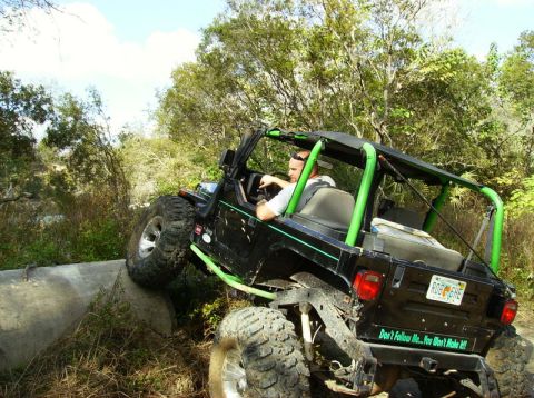 1989 Ford Bronco - Jeep Wrangler navigating an obstacle on an off-road trail.