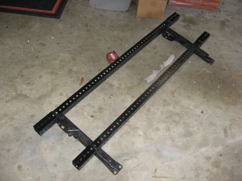 1979 Ford F-150 - A black metal seat frame is shown on a concrete floor, with a red measuring tape nearby.
