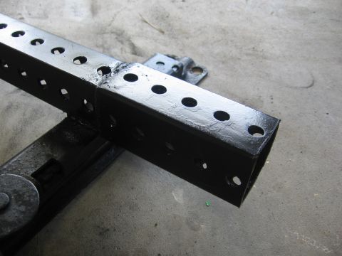 1979 Ford F-150 - Close-up of a black metal bracket with numerous holes, likely a vehicle part.
