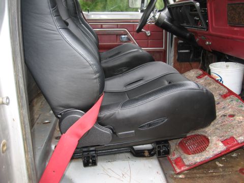 1979 Ford F-150 - Aftermarket black bucket seats with red seatbelts installed in the interior of a 1979 Ford F-150.