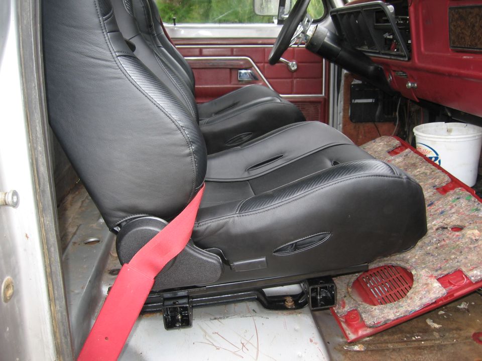 Black bucket seats with red seatbelt in a 1979 Ford F-150 interior