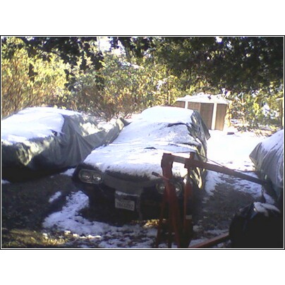 1972 Ford Ranchero - Multiple vehicles are covered in snow, with one showing its front end and a red engine hoist.