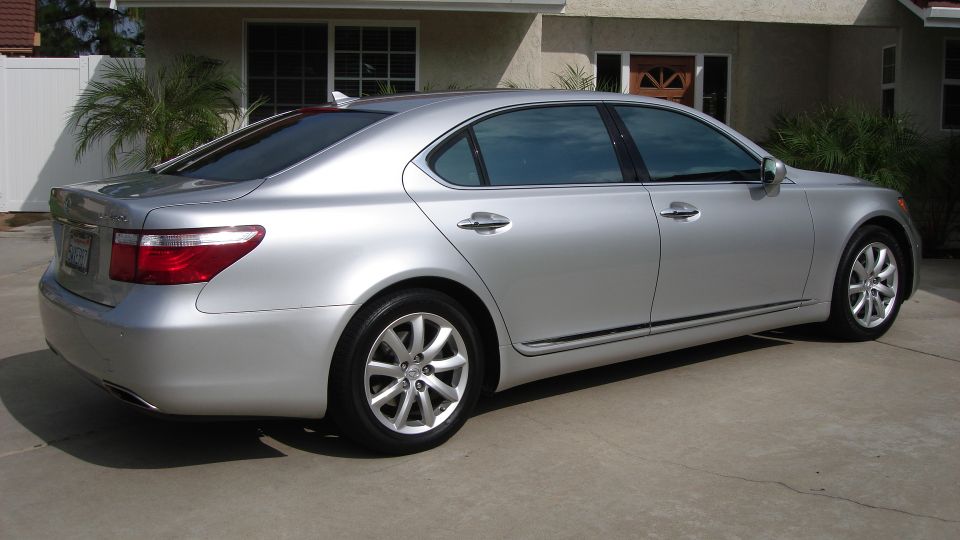 Silver Lexus LS sedan seen from rear passenger side in a driveway