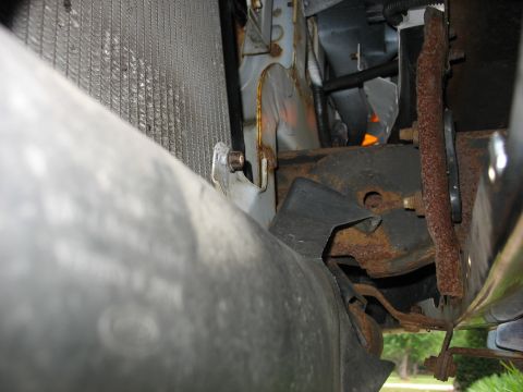 1995 Ford C-350 (Centurion Conversions) - Close-up view of vehicle's front-end components, including a radiator and rusted metal parts.