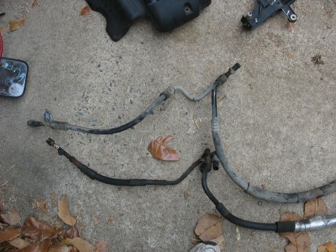 1995 Ford C-350 (Centurion Conversions) - Several AC hoses are shown on a concrete surface, possibly removed from a vehicle for repair or replacement.