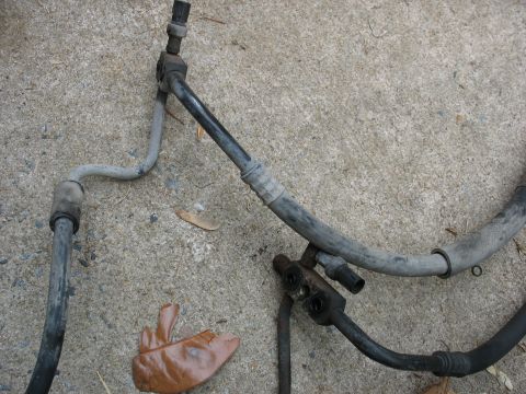 1995 Ford C-350 (Centurion Conversions) - A set of AC hoses and fittings are laid out on a concrete surface.