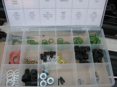 1995 Ford C-350 (Centurion Conversions) - A clear plastic organizer box contains various automotive parts, including O-rings and seals, neatly sorted into compartments.