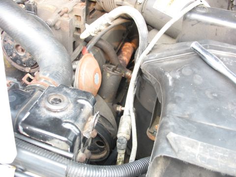 1995 Ford C-350 (Centurion Conversions) - A close-up view of the engine compartment focuses on the AC condenser and associated plumbing.
