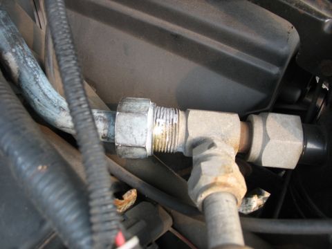 1995 Ford C-350 (Centurion Conversions) - This is a close-up view of a metal fitting connecting two AC lines in a vehicle's engine bay.