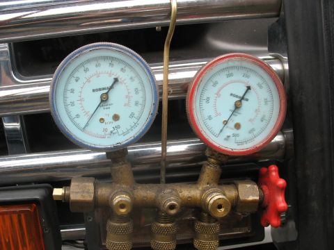 1995 Ford C-350 (Centurion Conversions) - AC manifold gauge set with blue and red gauges mounted in front of a chrome grille.