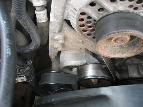 1995 Ford C-350 (Centurion Conversions) - Engine belt tensioner and pulley system detail. Wear is visible on the pulley's edge.