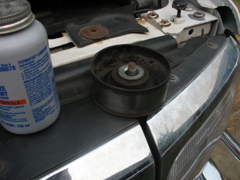 1995 Ford C-350 (Centurion Conversions) - A pulley and a bottle of lubricant are shown on the vehicle's engine bay, with part of the headlight visible.